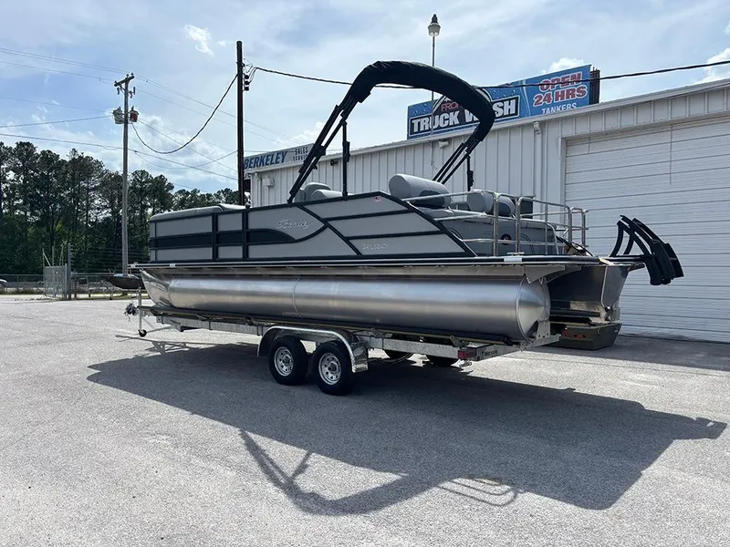 Slide: The Image of 2025 Bentley Pontoons Legacy QSB on trailer, parked outdoors near a building. - 2
