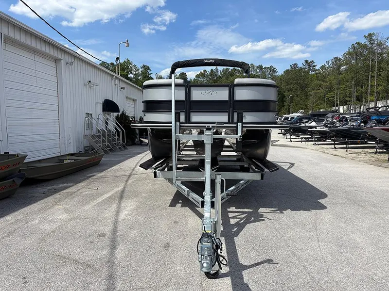 Slide: The Image of 2025 Bentley Pontoons Legacy QSB on trailer, parked outdoors under a clear sky. - 3