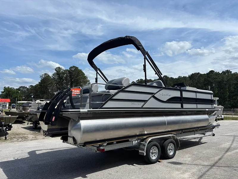 Slide: The Image of 2025 Bentley Pontoons Legacy QSB on trailer, sleek design, outdoor setting, blue sky background. - 6