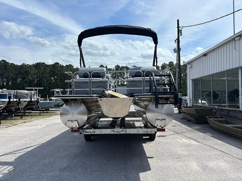 Slide: The Image of 2025 Bentley Pontoons Legacy QSB on trailer, parked outdoors near dealership. - 7