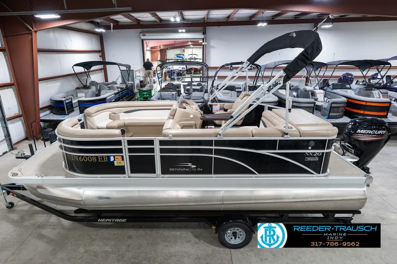 Slide: The Image of 2018 Bennington 20 SLMX pontoon boat in showroom, side view with trailer. - 1