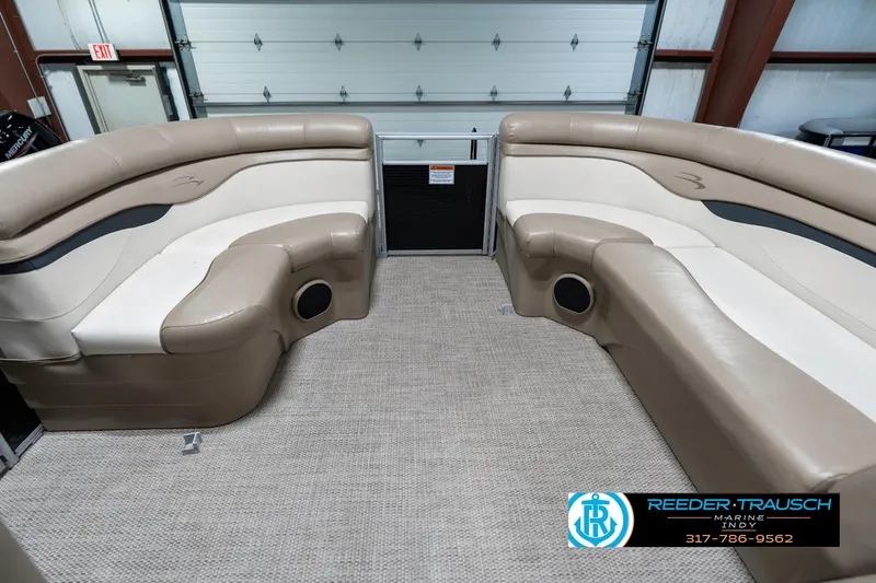 Slide: The Image of 2018 Bennington 20 SLMX pontoon boat interior with beige seating in a garage. - 22