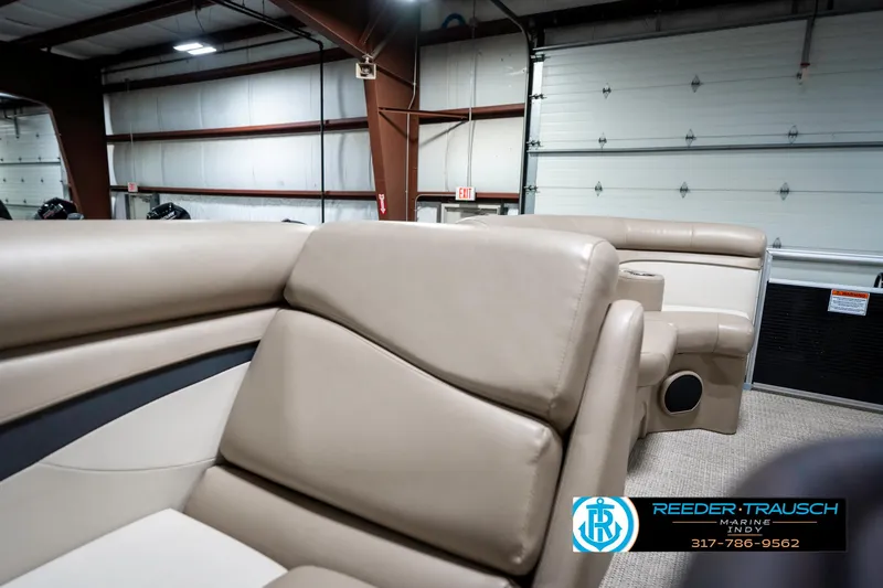 Slide: The Image of 2018 Bennington 20 SLMX pontoon boat interior with beige seating in a showroom. - 24