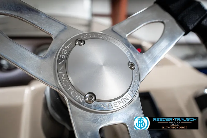 Slide: The Image of Steering wheel of a 2018 Bennington 20 SLMX boat with logo detail. - 34