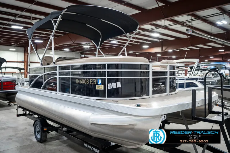 Slide: The Image of 2018 Bennington 20 SLMX pontoon boat with canopy in showroom, displayed on trailer. - 6