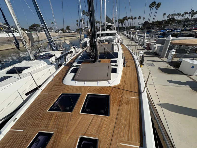 Slide: The Image of Dufour 560 Exclusive 2018 yacht with teak deck, docked at marina under clear sky. - 18