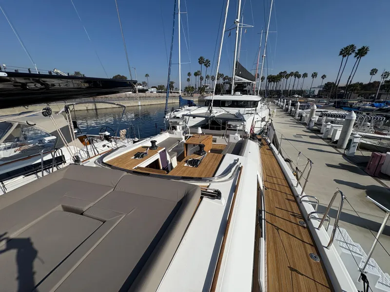 Slide: The Image of 2018 Dufour 560 Exclusive yacht docked at marina, showcasing spacious deck and elegant design. - 24