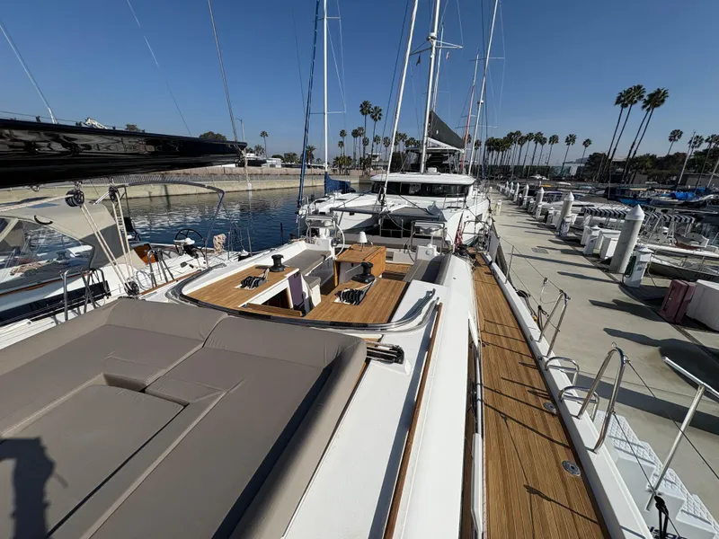 Slide: The Image of 2018 Dufour 560 Exclusive yacht docked at marina, showcasing spacious deck and sleek design. - 25