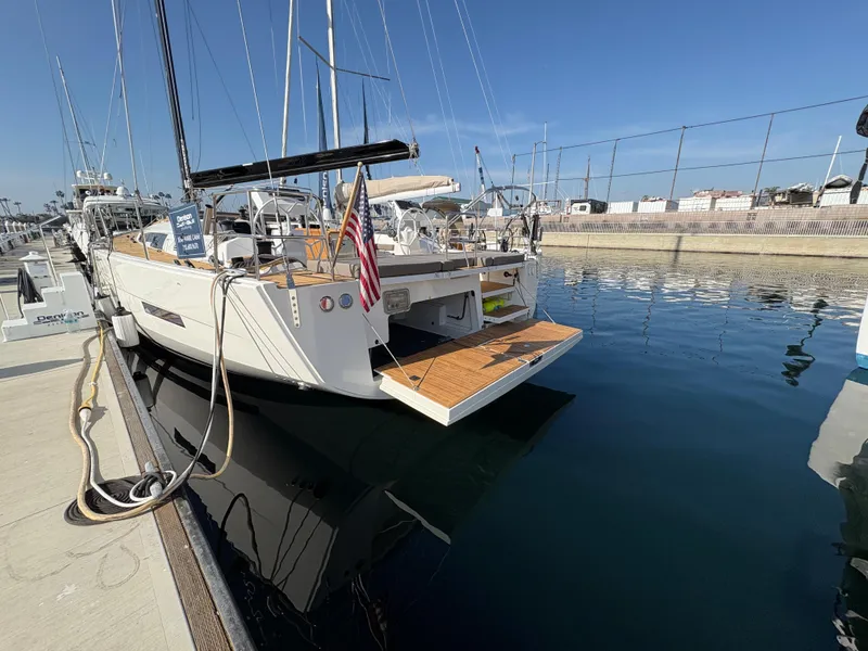 Slide: The Image of Dufour 560 Exclusive 2018 yacht docked at marina, rear view with open swim platform. - 26