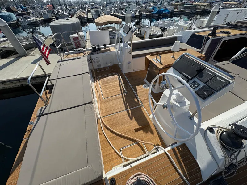 Slide: The Image of Dufour 560 Exclusive 2018 yacht cockpit with steering wheel and seating, docked at marina. - 6