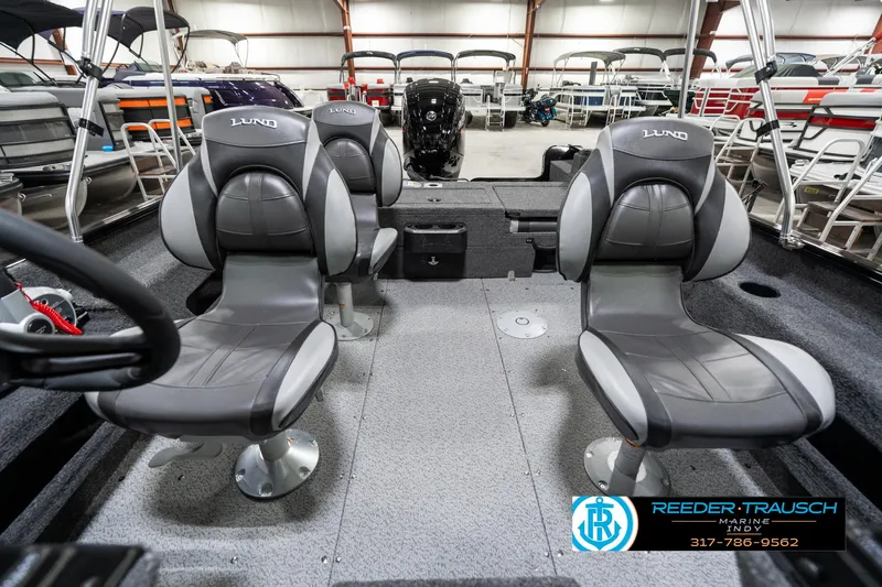 Slide: The Image of 2025 Lund 1775 Adventure Sport boat interior with two gray seats in a showroom. - 19