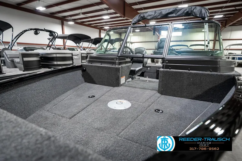 Slide: The Image of 2025 Lund 1775 Adventure Sport boat interior in showroom, featuring spacious seating and modern design. - 22