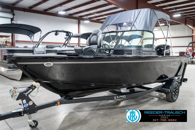 Slide: The Image of 2025 Lund 1775 Adventure Sport boat in showroom, black exterior, on trailer. - 3
