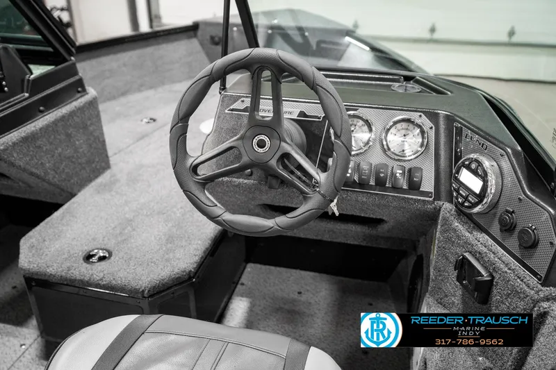 Slide: The Image of 2025 Lund 1775 Adventure Sport boat interior with steering wheel and dashboard controls. - 33