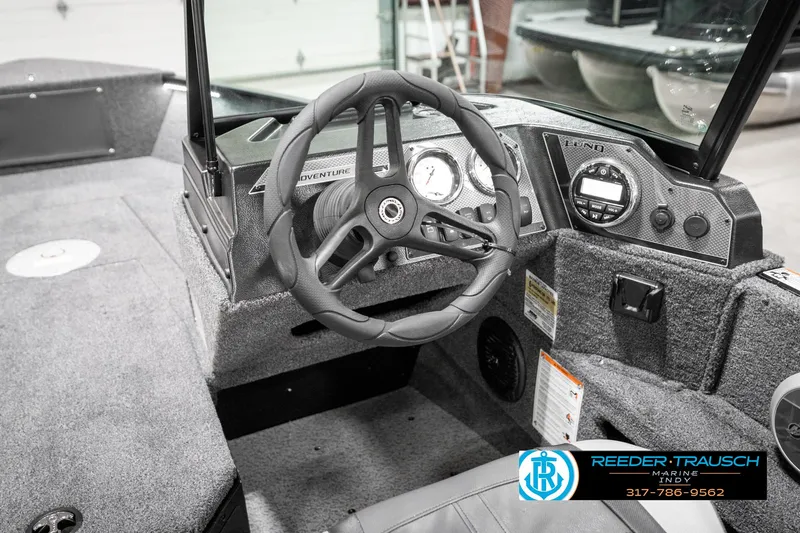 Slide: The Image of 2025 Lund 1775 Adventure Sport boat interior with steering wheel and dashboard controls. - 34