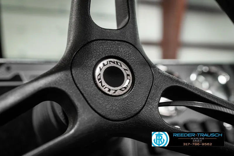 Slide: The Image of Steering wheel of 2025 Lund 1775 Adventure Sport boat, featuring logo detail. - 35