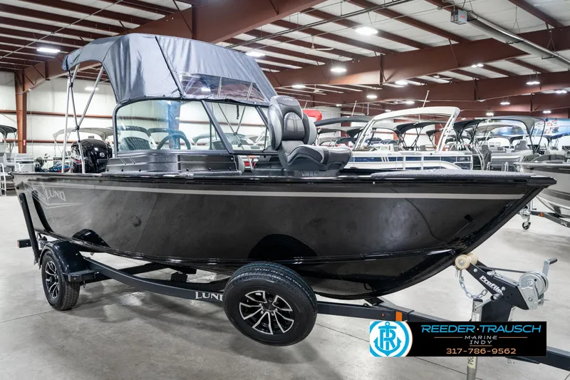 Slide: The Image of 2025 Lund 1775 Adventure Sport boat in showroom, black exterior, on trailer. - 5