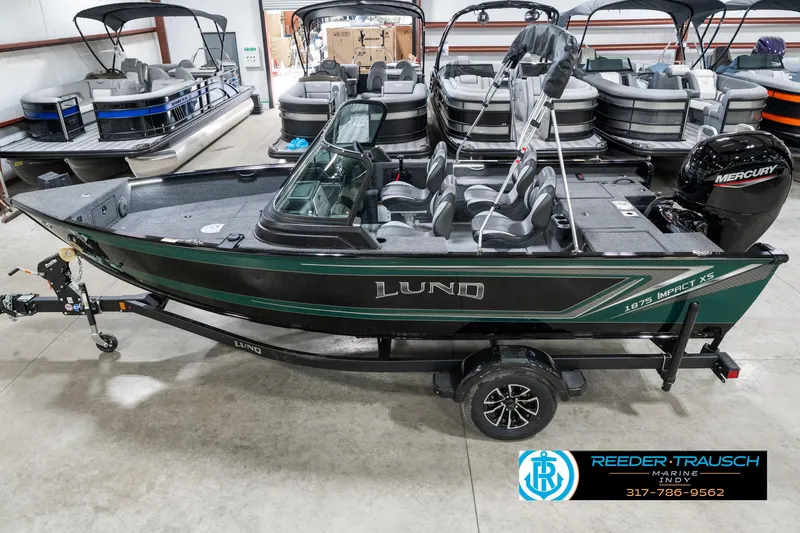 Slide: The Image of 2025 Lund 1875 Impact XS boat in showroom, featuring sleek design and Mercury engine. - 1
