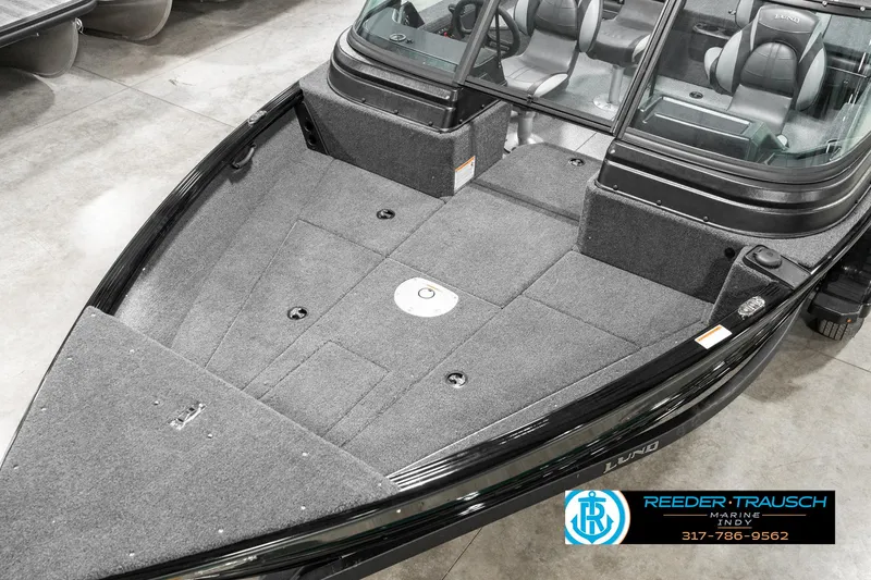 Slide: The Image of 2025 Lund 1875 Impact XS boat with spacious deck and seating, displayed indoors. - 12