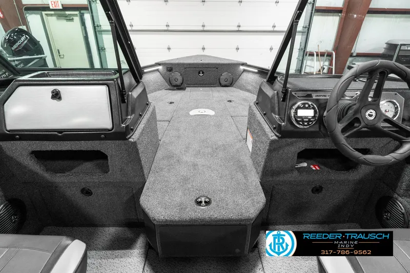 Slide: The Image of 2025 Lund 1875 Impact XS boat interior with steering wheel and dashboard controls. - 17