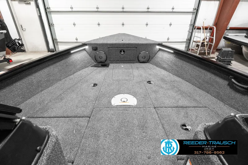 Slide: The Image of 2025 Lund 1875 Impact XS boat interior with carpeted deck and storage compartments. - 18