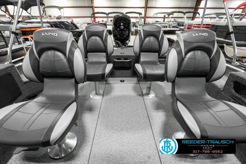 Slide: The Image of 2025 Lund 1875 Impact XS boat interior with four gray seats in a showroom. - 20