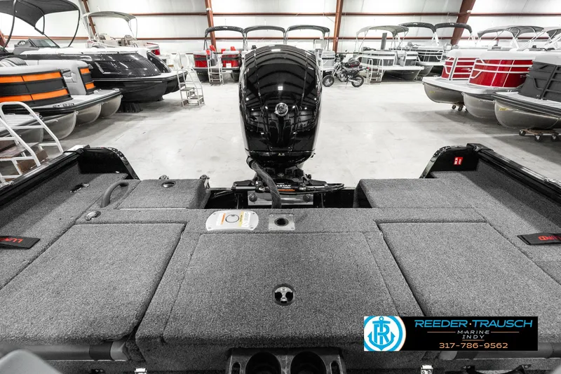 Slide: The Image of 2025 Lund 1875 Impact XS boat interior with motor, displayed in a showroom. - 21