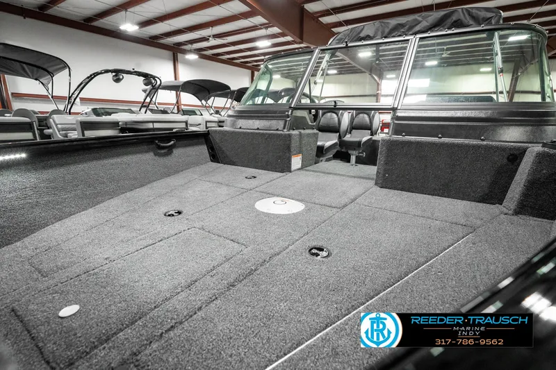 Slide: The Image of 2025 Lund 1875 Impact XS boat interior with spacious deck in showroom. - 22