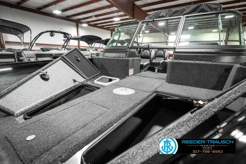Slide: The Image of 2025 Lund 1875 Impact XS boat interior with open storage compartments in showroom. - 23