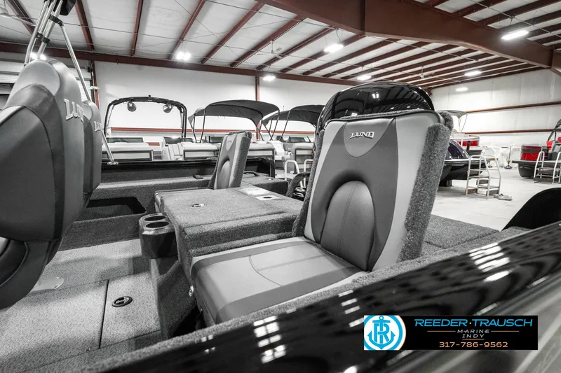 Slide: The Image of 2025 Lund 1875 Impact XS boat interior with seating in a showroom. - 26