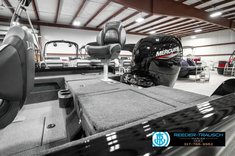 Slide: The Image of 2025 Lund 1875 Impact XS boat interior with Mercury engine in showroom. - 29