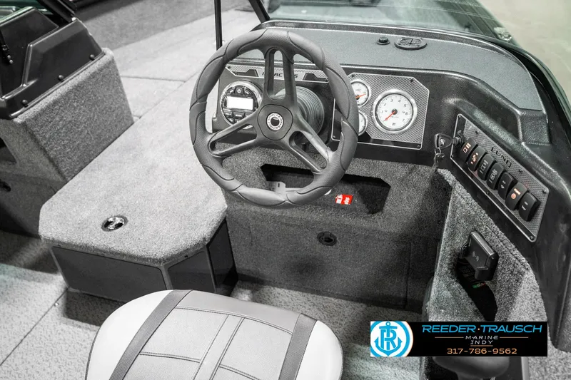 Slide: The Image of 2025 Lund 1875 Impact XS boat interior with steering wheel and dashboard controls. - 37