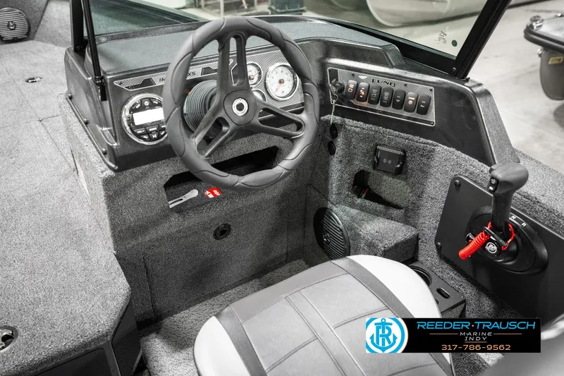 Slide: The Image of 2025 Lund 1875 Impact XS boat interior with steering wheel and control panel. - 38