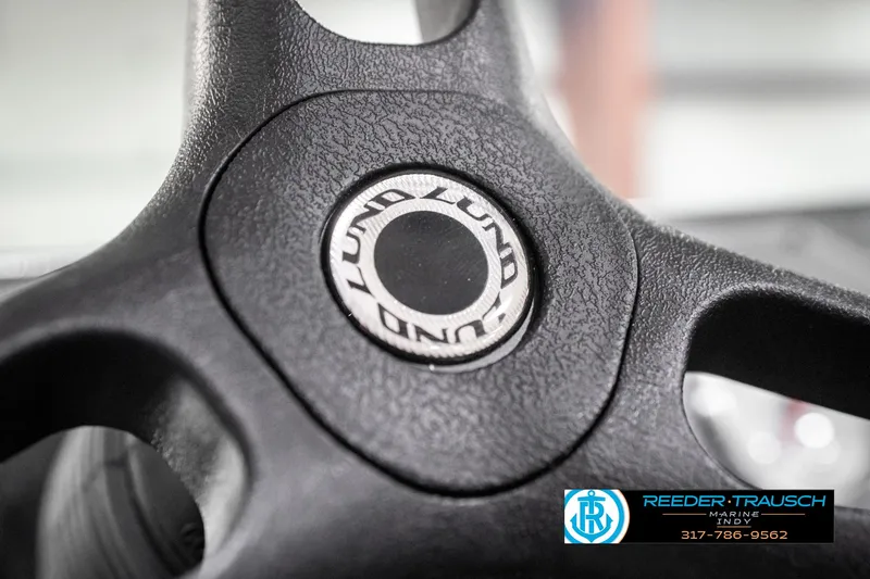 Slide: The Image of Steering wheel of 2025 Lund 1875 Impact XS boat, featuring brand logo. - 39