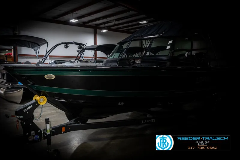 Slide: The Image of 2025 Lund 1875 Impact XS boat in a dimly lit indoor setting. - 4