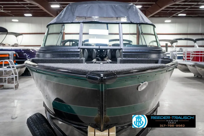 Slide: The Image of 2025 Lund 1875 Impact XS boat in showroom, front view, with Reeder-Trausch Marine logo. - 5