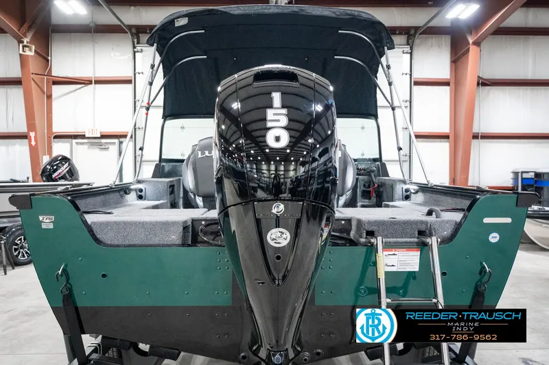 Slide: The Image of 2025 Lund 1875 Impact XS boat with powerful 150 HP engine in showroom. - 9
