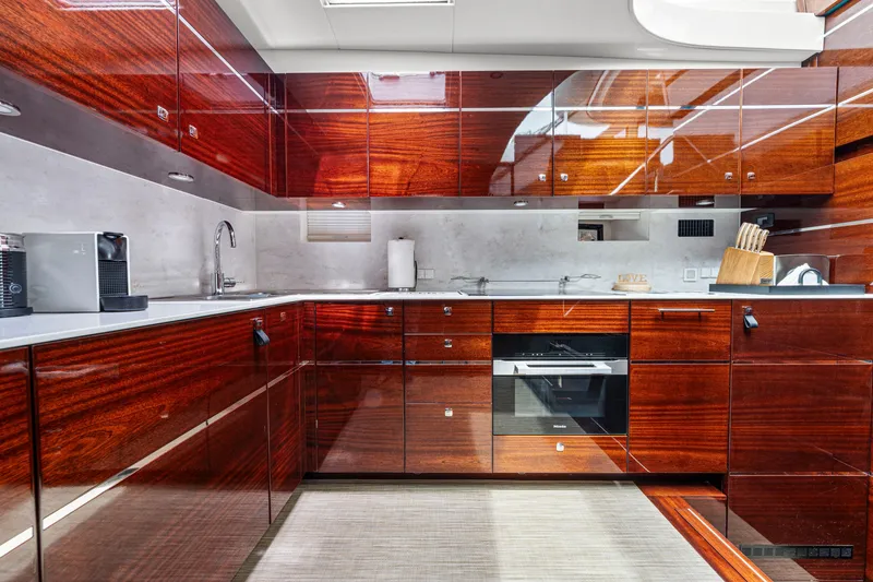 Slide: The Image of Luxurious yacht kitchen with glossy wood cabinets, modern appliances, and sleek design. Steeler 60 S Performance 2021. - 40
