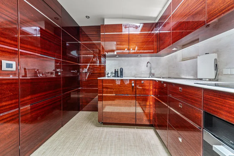 Slide: The Image of Luxurious yacht kitchen with glossy wooden cabinets, modern appliances, and sleek design. Steeler 60 S Performance 2021. - 42