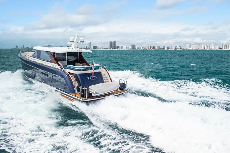 Slide: The Image of Steeler 60 S Performance yacht cruising in open water, city skyline in background, 2021 model. - 8