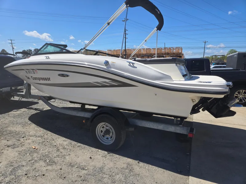 Slide: The Image of 2015 Sea Ray SPX 190 boat on trailer, parked outdoors under clear sky. - 2