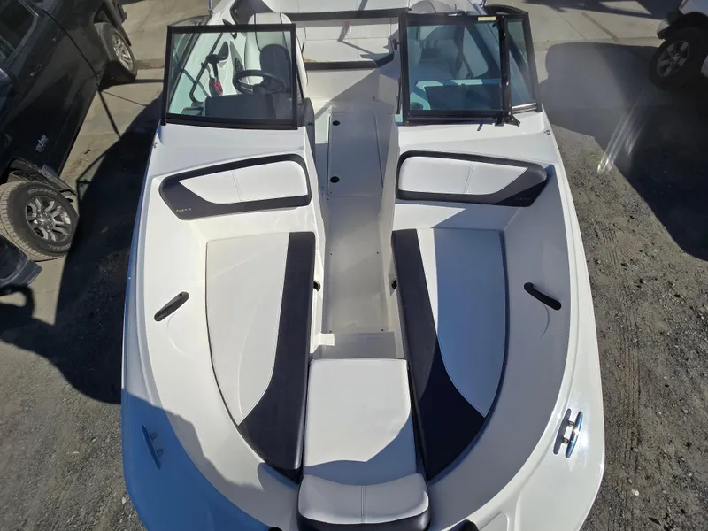 Slide: The Image of 2015 Sea Ray SPX 190 boat interior with seating and windshield, parked on gravel. - 20