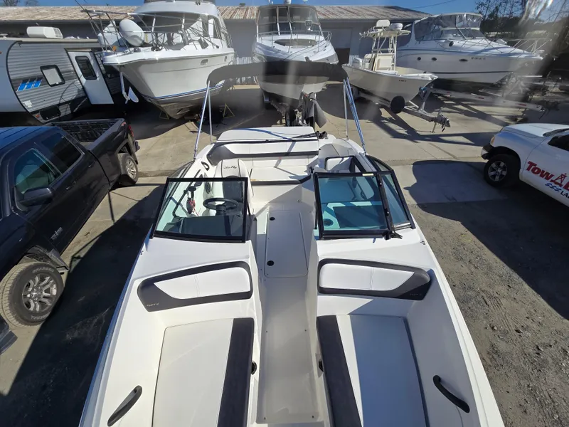 Slide: The Image of 2015 Sea Ray SPX 190 boat in a marina, surrounded by other vessels. - 21