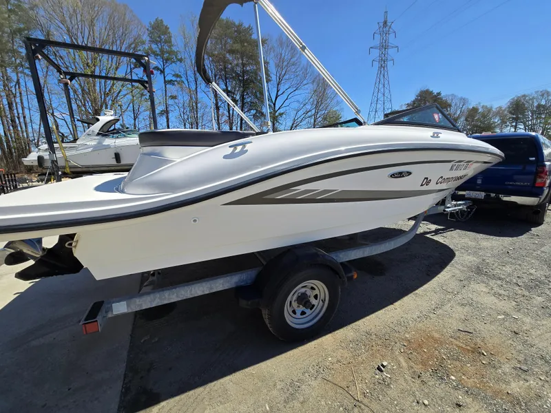 Slide: The Image of 2015 Sea Ray SPX 190 boat on trailer, parked outdoors under clear sky. - 3