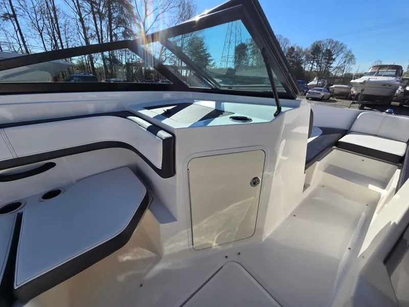 Slide: The Image of 2015 Sea Ray SPX 190 boat interior with seating and storage, under clear blue sky. - 33