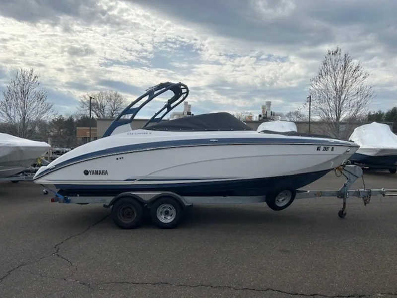 Slide: The Image of 2014 Yamaha Boats 242 Limited S on trailer, parked outdoors under cloudy sky. - 4