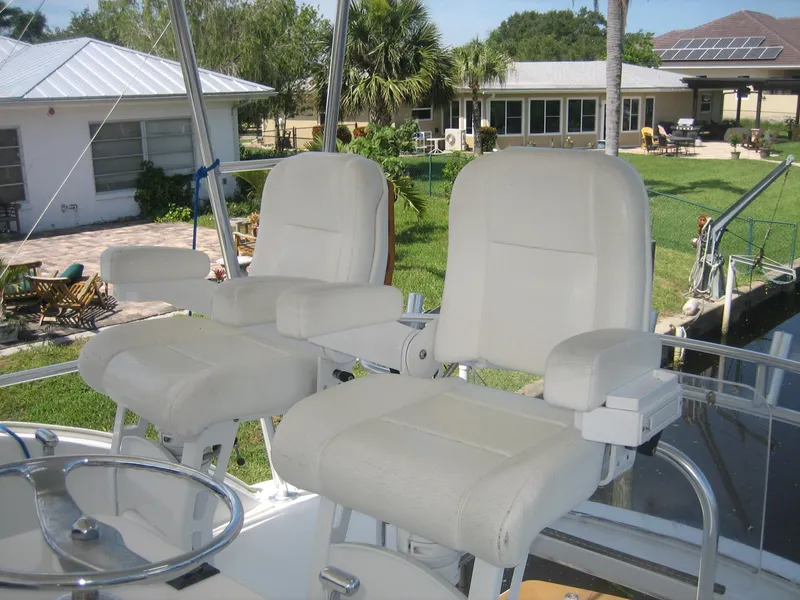Slide: The Image of Captain's chairs on 2005 Ocean Yachts 50 Super Sport, docked near waterfront homes. - 3