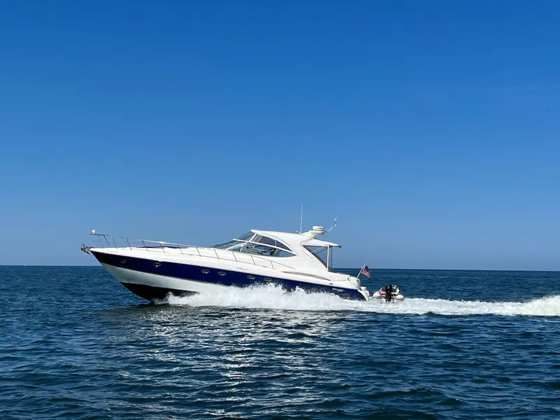 Slide: The Image of 2005 Cruisers Yachts 540 Express cruising on open water under clear blue skies. - 1