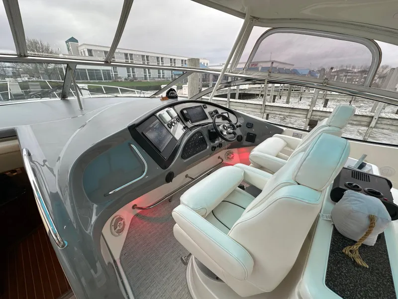 Slide: The Image of Helm of 2005 Cruisers Yachts 540 Express with modern controls and plush seating. - 11