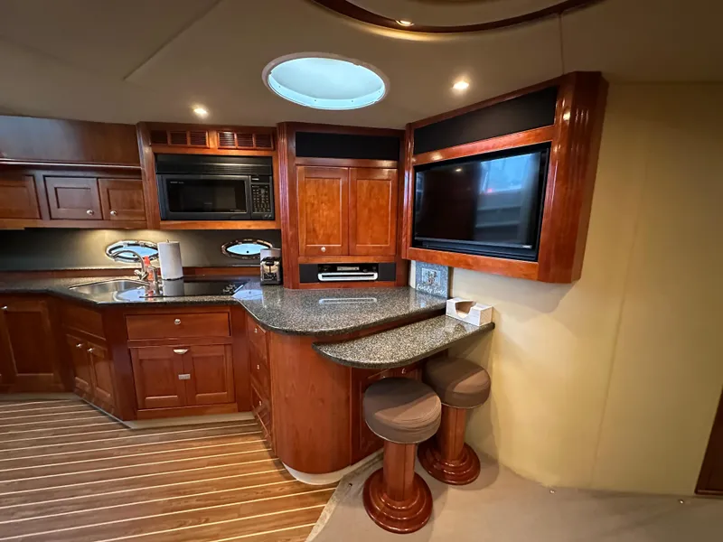 Slide: The Image of Luxurious 2005 Cruisers Yachts 540 Express interior with wood cabinetry and modern amenities. - 21